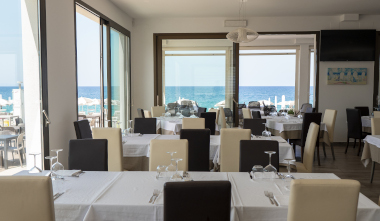 il ristorante del tropix, a schiavonea, con i tavoli del portico quasi sul mare che bagna corigliano-rossano